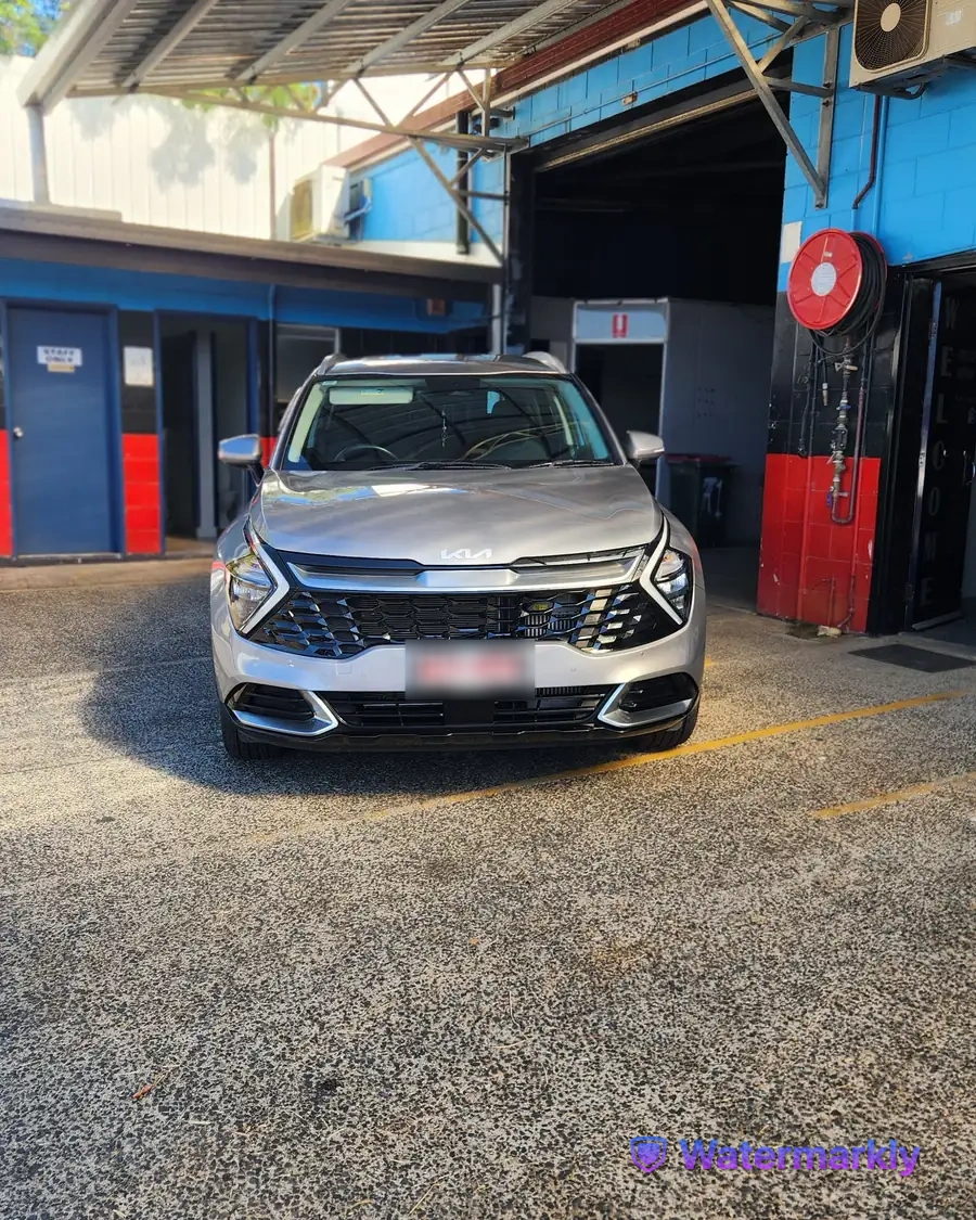 Panel beater checking a repaired body line at A1 Collision Repair Centre in Innisfail